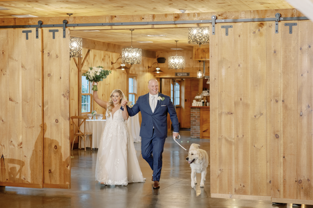 Newly married couple with their dog entering the wedding reception.
